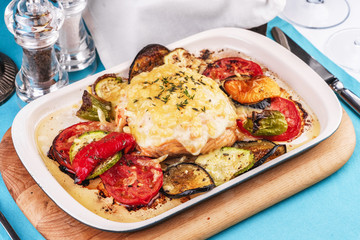 Mediterranean dish, Georgian recipe. Baked chicken steak with lemon, vegetables, pepper, zucchini, eggplants and grilled tomatoes with spices
