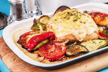 Mediterranean dish, Georgian recipe. Baked chicken steak with lemon, vegetables, pepper, zucchini, eggplants and grilled tomatoes with spices