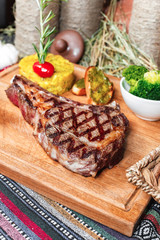 T bon steak fried on charcoal. Grilled meat with mashed potatoes, broccoli, tomato sauce and croutons in oriental style, Georgian appetizer. National cuisine