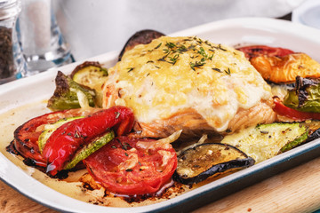 Mediterranean dish, Georgian recipe. Baked chicken steak with lemon, vegetables, pepper, zucchini, eggplants and grilled tomatoes with spices
