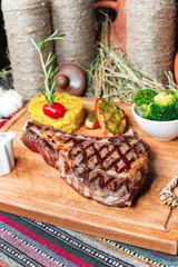 T bon steak fried on charcoal. Grilled meat with mashed potatoes, broccoli, tomato sauce and croutons in oriental style, Georgian appetizer. National cuisine