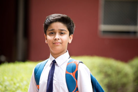 Portrait of schoolboy standing at school campus