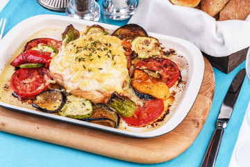 Mediterranean dish, Georgian recipe. Baked chicken steak with lemon, vegetables, pepper, zucchini, eggplants and grilled tomatoes with spices