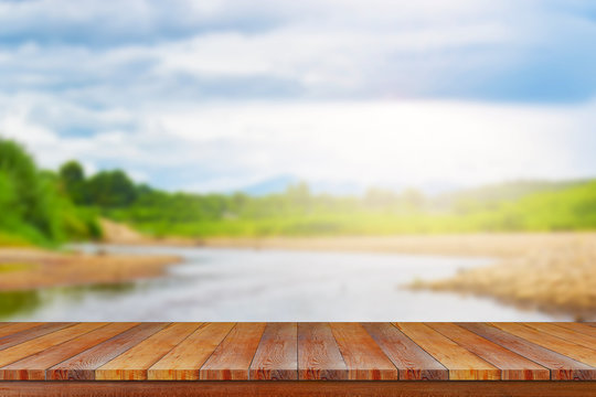 wood table with soft sunlight on river background