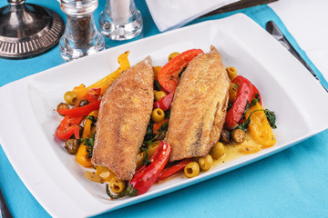 Grilled fish steak carp served with stewed chili peppers, olives, olives, greens and green pepper according to the Georgian recipe. Mediterranean Kitchen 