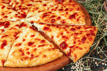 Georgian national dish with cheese and greens -hachapuri. Baked dough in the oven with Kahumi cheese and fragrant spices. National cuisine