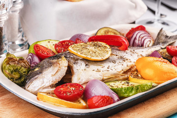 Mediterranean dish, Georgian recipe. Baked river fish with lemon, vegetables, pepper and grilled...