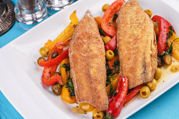 Grilled fish steak carp served with stewed chili peppers, olives, olives, greens and green pepper according to the Georgian recipe. Mediterranean Kitchen 