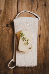 Washcloth with  soap with herb  on wooden  background.