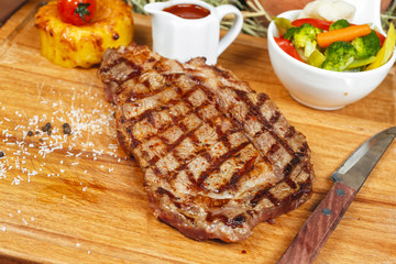 grilled beef steak according to Georgian recipe. Served with tomato sauce and fresh vegetable salad. National cuisine