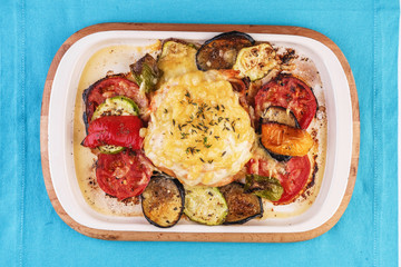Mediterranean dish, Georgian recipe. Baked chicken steak with lemon, vegetables, pepper, zucchini, eggplants and grilled tomatoes with spices