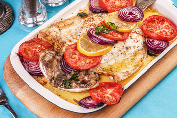 Seafood, Mediterranean cuisine, European dish. Baked entirely in foil fish with onion rings, pimodori, zucchini and baclazans under fragrant spices. Caucasian national cuisine