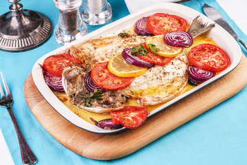 Seafood, Mediterranean cuisine, European dish. Baked entirely in foil fish with onion rings, pimodori, zucchini and baclazans under fragrant spices. Caucasian national cuisine