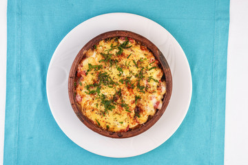 European cuisine, Mediterranean dish. Stew of meat, vegetables and seafood, baked in a pot under a cheese crust