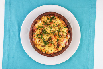 European cuisine, Mediterranean dish. Stew of meat, vegetables and seafood, baked in a pot under a cheese crust