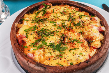 European cuisine, Mediterranean dish. Stew of meat, vegetables and seafood, baked in a pot under a cheese crust