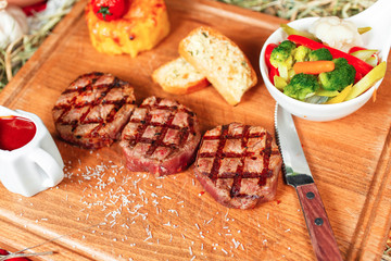 Grilled veal medallions with sauces served with steamed vegetables - cauliflower, broccoli, carrots, tomatoes and mashed potatoes according to the Georgian recipe. National cuisine