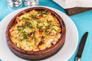 European cuisine, Mediterranean dish. Stew of meat, vegetables and seafood, baked in a pot under a cheese crust