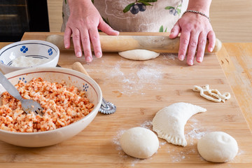 Close up of female hands preparing panzerotto, typical street food of Puglia