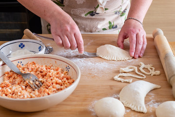 Woman making panzerotto on a wooden table. Typical food of Puglia