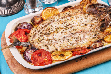 Seafood, Mediterranean cuisine, European dish. Baked entirely in foil fish with onion rings, pimodori, zucchini and baclazans under fragrant spices. Caucasian national cuisine