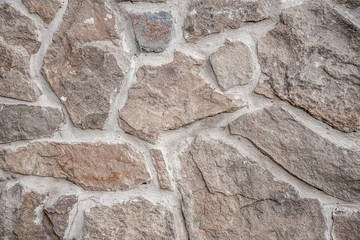 Old wall made of red natural stone. Rough concrete surface. Wall texture in grunge style. Stone background for shooting flat lay. Construction and interior design concept. Copy space