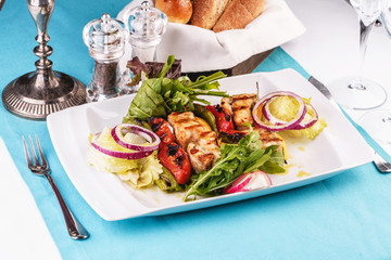  Seafood, Mediterranean cuisine, European dish. salad of assorted fish pieces grilled, with grilled vegetables - with onion rings, red and green pepper, chili pepper, greens, cheese, mushrooms 