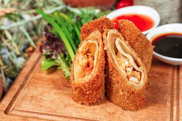  Georgian appetizer - cheese roll with greens, deep fried in a thin plate. Served with sauce, pepper and greens, cabbage. National cuisine