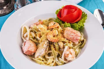  Mediterranean dish, Georgian recipe. Creamy pasta with shrimps, crab meat, seafood, squid rings, tomatoes, basil, greens and cheese.