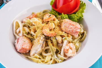  Mediterranean dish, Georgian recipe. Creamy pasta with shrimps, crab meat, seafood, squid rings, tomatoes, basil, greens and cheese.