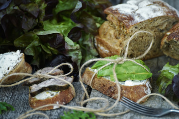 Plain sandwiches with baked meat and avocados on a rough wooden background. Simple farm food.