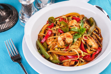 Mediterranean dish, Georgian recipe. Pasta with shrimps, red and green pepper, basil