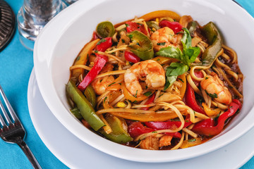 Mediterranean dish, Georgian recipe. Pasta with shrimps, red and green pepper, basil
