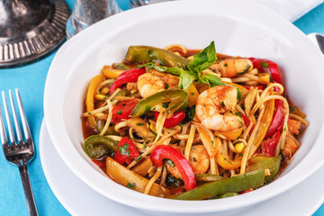 Mediterranean dish, Georgian recipe. Pasta with shrimps, red and green pepper, basil