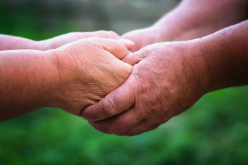 Two elderly people are holding hands. Hand in hand.