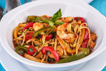 Mediterranean dish, Georgian recipe. Pasta with shrimps, red and green pepper, basil