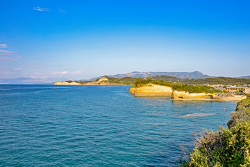 Aerial view of green rocky cliffs in the ocean.