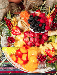  Fruit plate in Georgian style. Sliced ​​fruits - apple, banana, pineapple, orange, pear, grapes, persimmon, served with strawberries, raspberries, blackberries, blueberries in powdered sugar