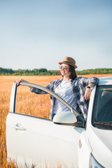 Beautiful woman with white car in the field