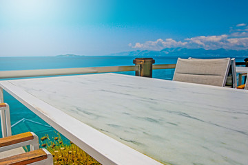 White table background with ocean and sunny blue sky view.