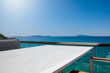 Obraz na płótnie Canvas White table background with ocean and sunny blue sky view.