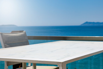 Obraz premium White table background with ocean and sunny blue sky view.
