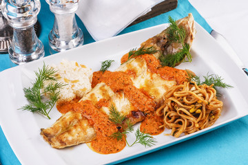 Baked fish in batter with caviar sauce, served with noodles in soy sauce, with rice and corn according to the Georgian recipe. Mediterranean Kitchen 