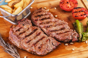 grilled beef steak with grilled pepper, onion rings and tomatoes. served with potato wedges and thyme. according to the Georgian recipe