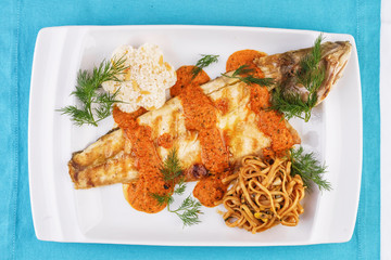 Baked fish in batter with caviar sauce, served with noodles in soy sauce, with rice and corn according to the Georgian recipe. Mediterranean Kitchen 