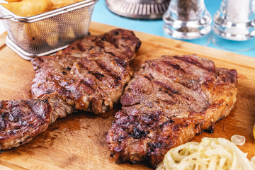 grilled beef steak with grilled pepper, onion rings and tomatoes. served with potato wedges and thyme. according to the Georgian recipe