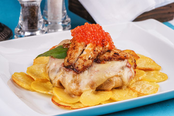 Seafood, Mediterranean cuisine, European dish. Sea salmon Fish steak with greens, country-style fried potatoes, cheese and cream sauce. Caucasian national cuisine