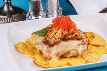 Seafood, Mediterranean cuisine, European dish. Sea salmon Fish steak with greens, country-style fried potatoes, cheese and cream sauce. Caucasian national cuisine