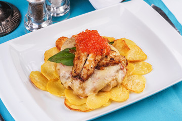 Seafood, Mediterranean cuisine, European dish. Sea salmon Fish steak with greens, country-style fried potatoes, cheese and cream sauce. Caucasian national cuisine