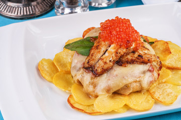 Seafood, Mediterranean cuisine, European dish. Sea salmon Fish steak with greens, country-style fried potatoes, cheese and cream sauce. Caucasian national cuisine